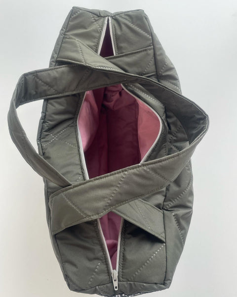 Taske i army quilt med lyserødt foer og lynlås.