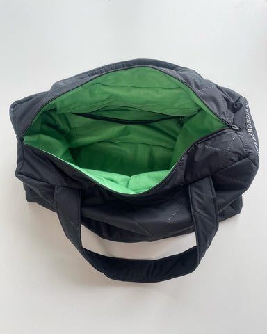 Taske i charcoal quilt med grønt foer og lommer.