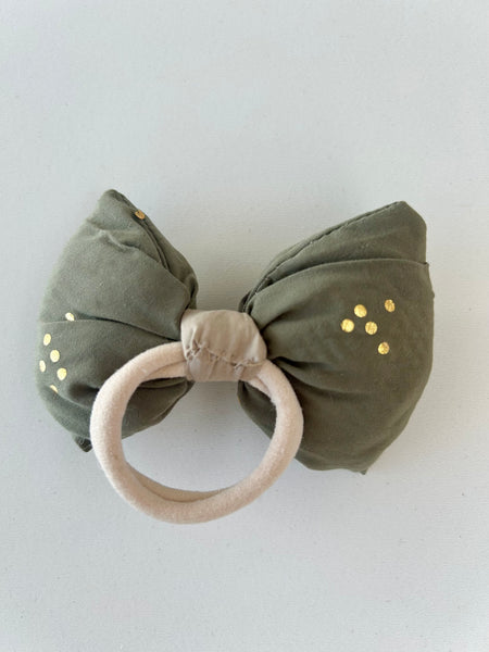 Stor sløjfe i støvet grøn med guld prikker.