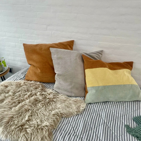 Pudebetræk i gul, cognac og beige fløjl.