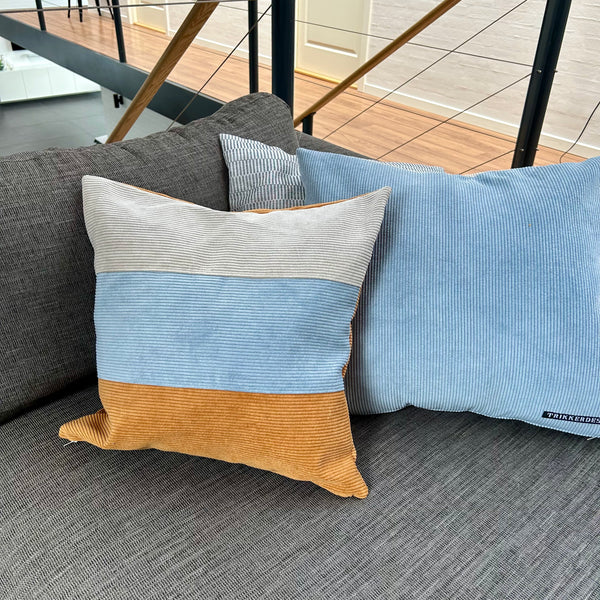 Pudebetræk i gyldenbrun, mørk kit og pastelblå, og med gyldenbrun bagside