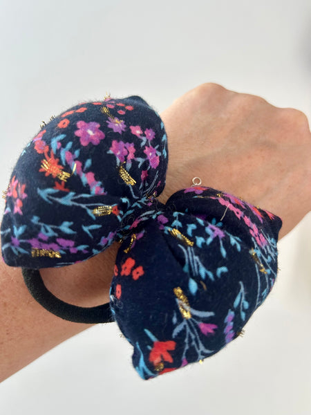 Mellem blomstret sløjfe med guld detaljer.