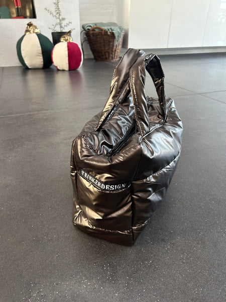 Håndtaske i skinnende brunt stof.