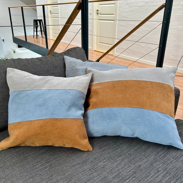 Pudebetræk i gyldenbrun, mørk kit og pastelblå, og med gyldenbrun bagside