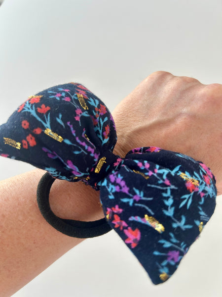 Sløjfe med gulddetaljer og blomster.