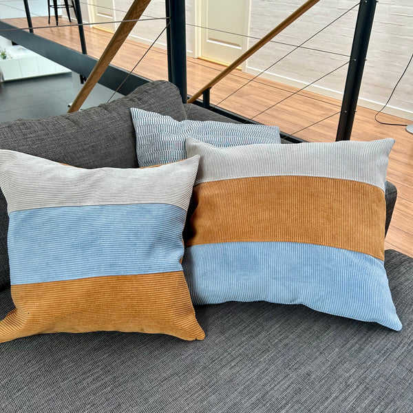 Pudebetræk i gyldenbrun, mørk kit og pastelblå, og med gyldenbrun bagside