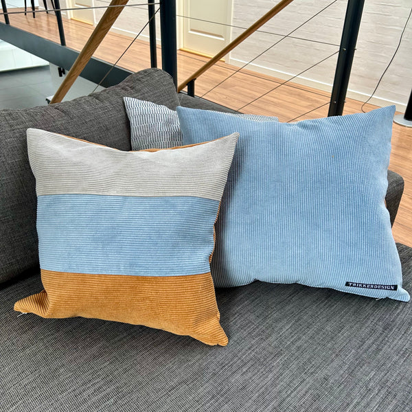 Pudebetræk i gyldenbrun, mørk kit og pastelblå, og med gyldenbrun bagside