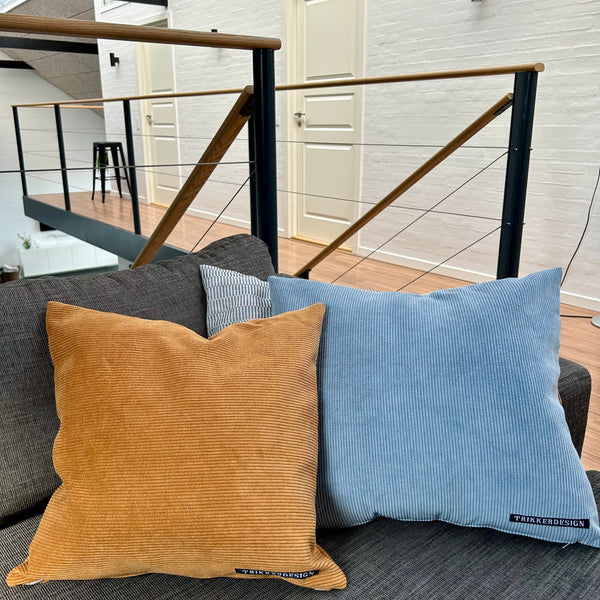 Pudebetræk i gyldenbrun, mørk kit og pastelblå, og med gyldenbrun bagside