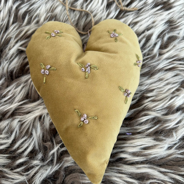 Hjerte i gullige toner og med broderede blomster.