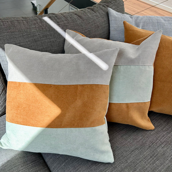 Pudebetræk i gylden brun, lys salvie og mørk kit. Mørk kit på bagsiden.