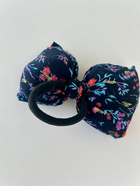 Stor fluffy sløjfe med blomster og guld detaljer.