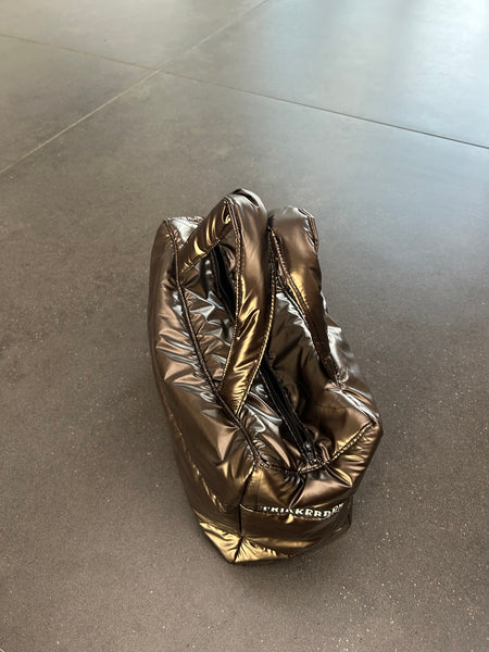 Håndtaske i skinnende brunt stof.