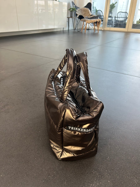 Håndtaske i skinnende brunt stof.