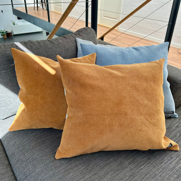 Pudebetræk i lys salvie, gylden brun og pastel blå. Bagsiden er gylden brun.