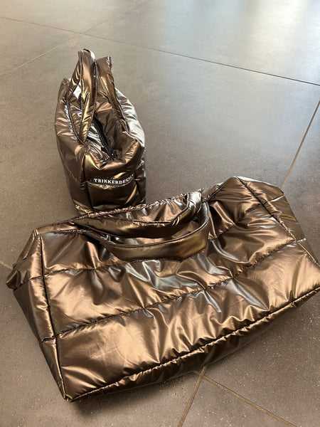 Håndtaske i skinnende brunt stof.