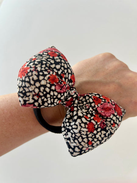 Fluffy sløjfe med blomster i rød, hvid og sort.