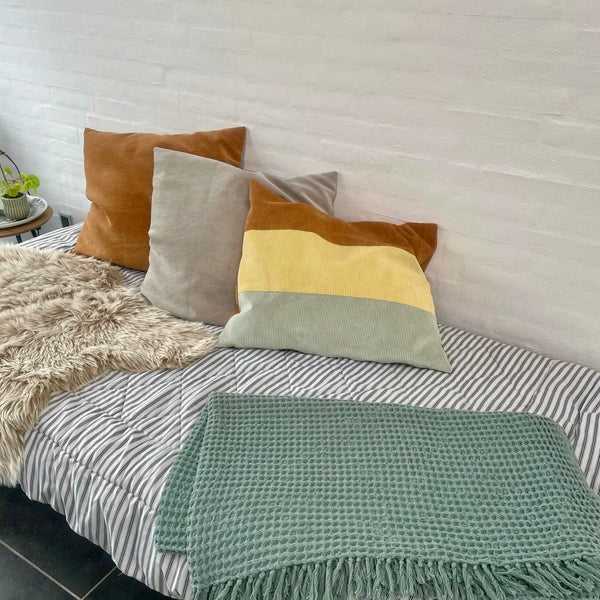 Pudebetræk i gul, cognac og beige fløjl.