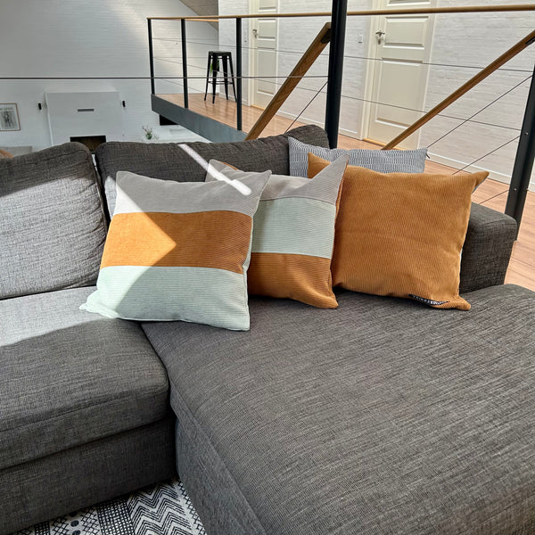 Pudebetræk i gylden brun, lys salvie og mørk kit. Mørk kit på bagsiden.