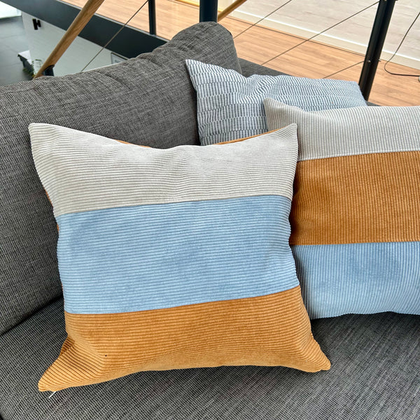 Pudebetræk i gyldenbrun, mørk kit og pastelblå, og med gyldenbrun bagside