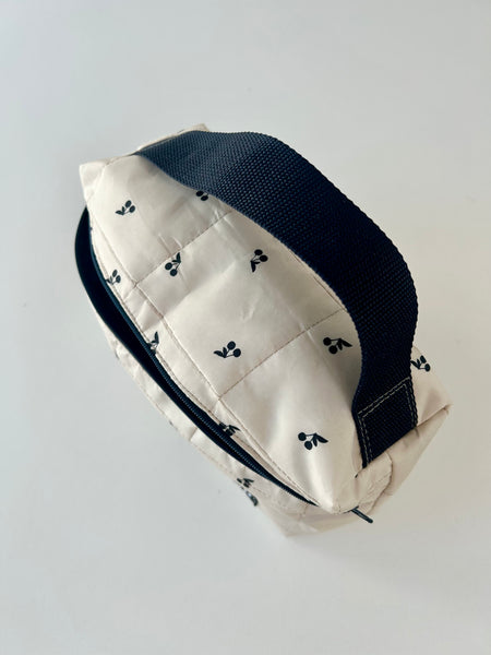 Skøn og rummelig toilettaske i råhvid med sorte kirsebær.