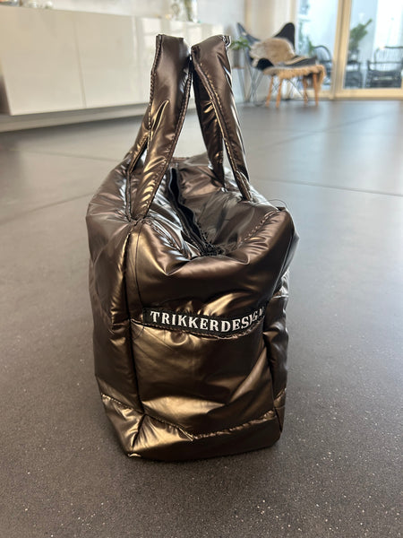 Håndtaske i skinnende brunt stof.