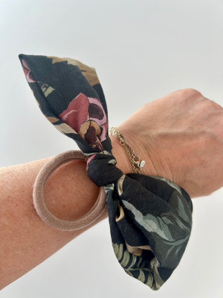 Stor stofsløjfe med blomster og blade.