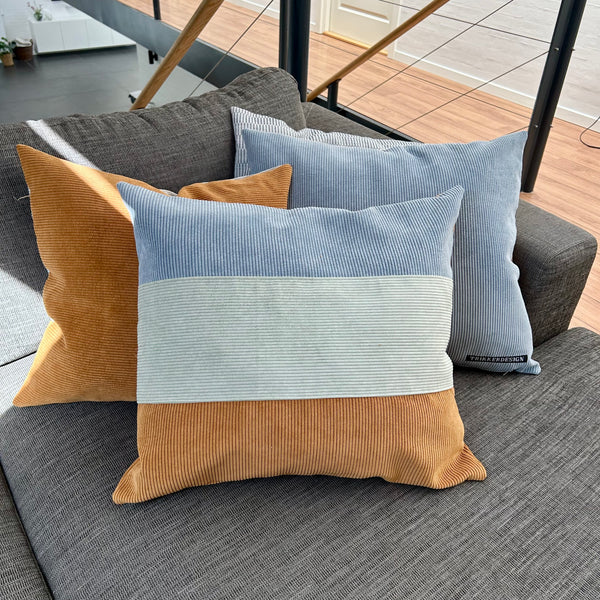 Pudebetræk i lys salvie, gylden brun og pastel blå. Bagsiden er gylden brun.