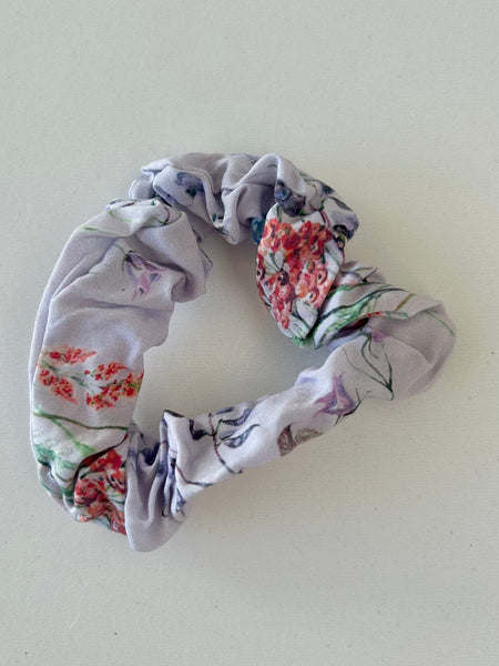 Smal scrunchie i lys lilla med blomster.