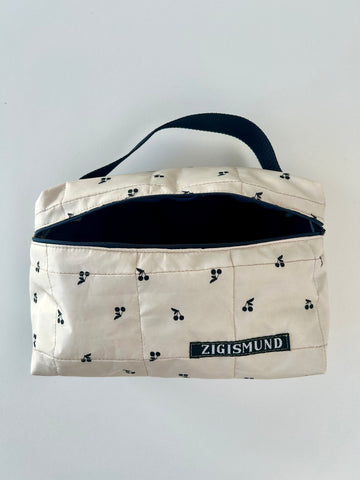 Skøn og rummelig toilettaske i råhvid med sorte kirsebær.