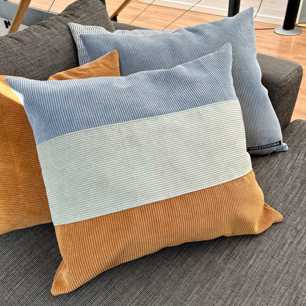 Pudebetræk i lys salvie, gylden brun og pastel blå. Bagsiden er gylden brun.