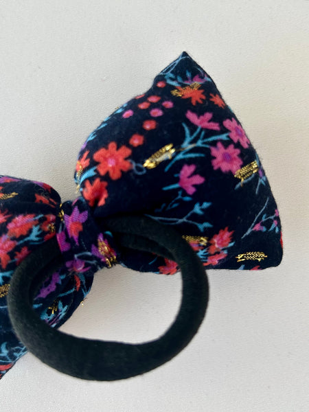 Sløjfe med gulddetaljer og blomster.