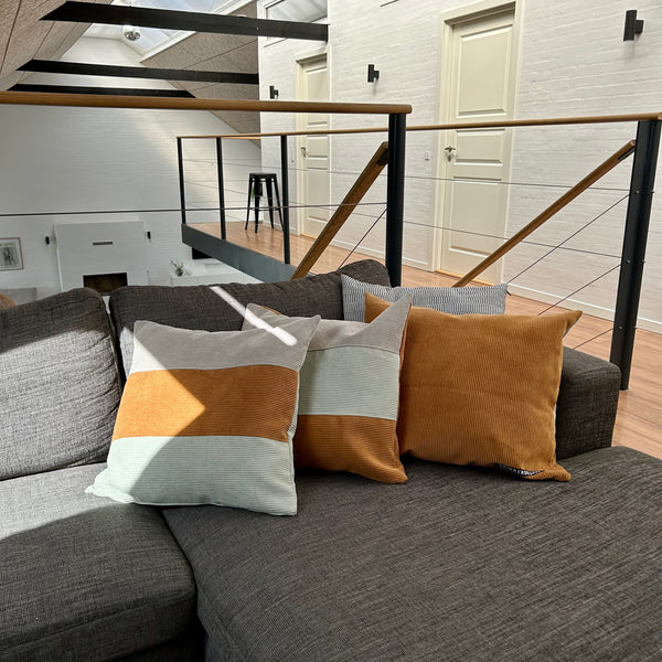 Pudebetræk i gylden brun, lys salvie og mørk kit. Mørk kit på bagsiden.