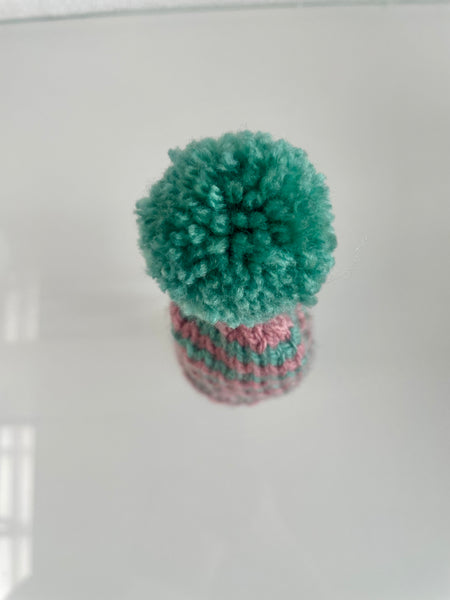 Æggevarmer ska Nissehue i lyserød og turkis strik med pom pom.