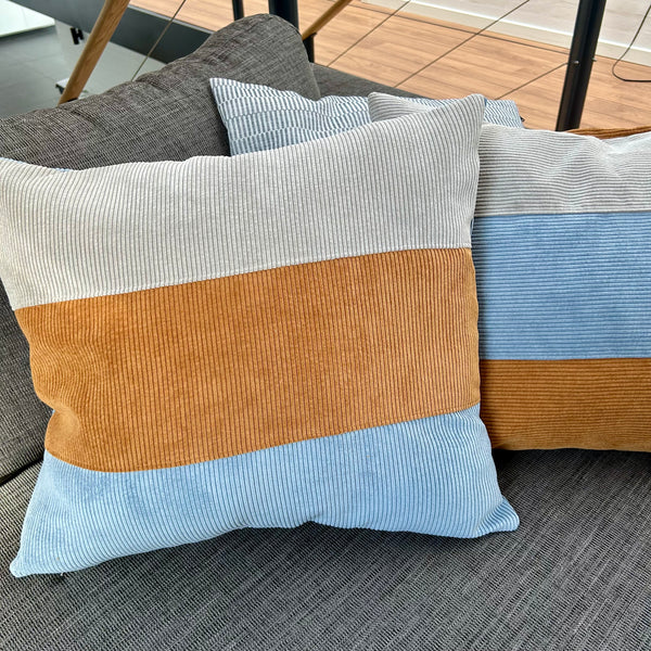 Pudebetræk i gyldenbrun, pastel blå og mørk kit. Pastel blå bagside.