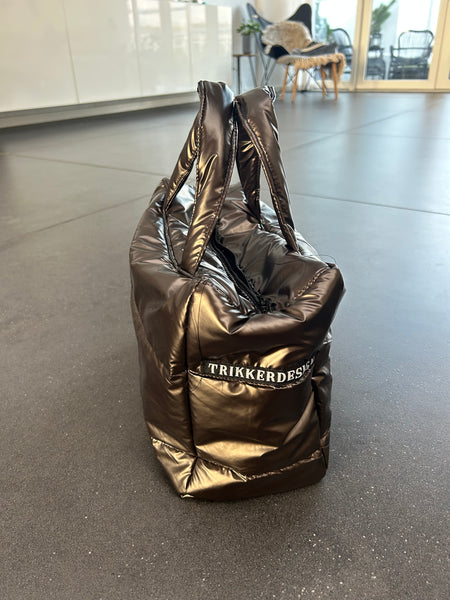 Håndtaske i skinnende brunt stof.