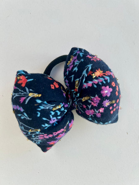 Mellem blomstret sløjfe med guld detaljer.