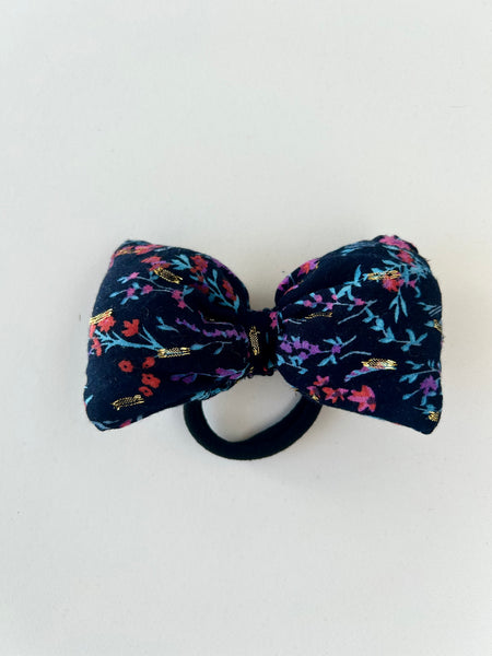 Sløjfe med gulddetaljer og blomster.