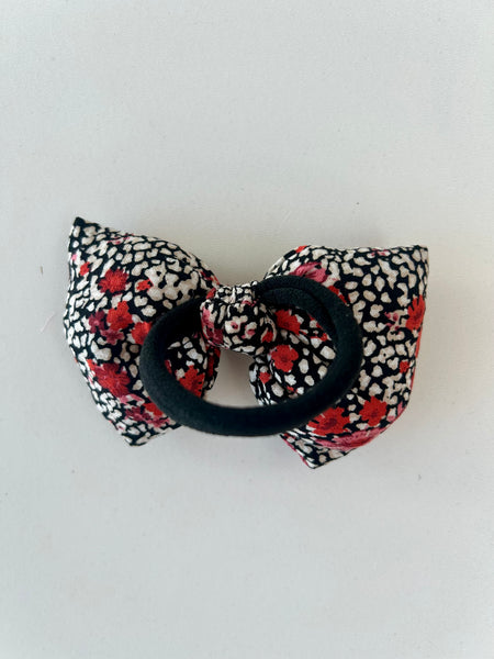Fluffy sløjfe med blomster i rød, hvid og sort.