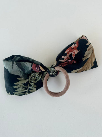 Stor stofsløjfe med blomster og blade.