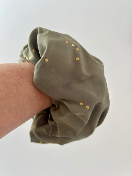 Stor scrunchie i støvet grøn med guld prikker.
