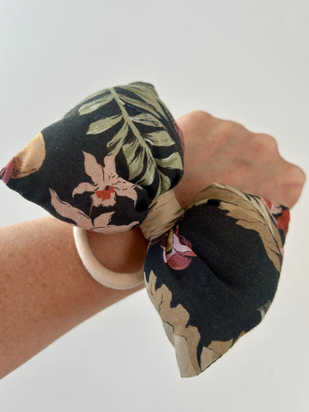 Skøn og fluffy blomstret sløjfe i sort og brunlige farver.