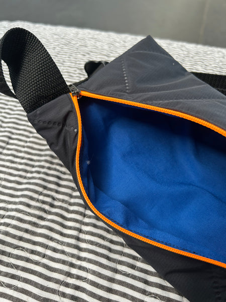 Bæltetaske i charcoal med orange lynlås.