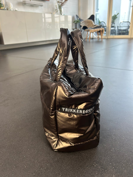 Håndtaske i skinnende brunt stof.