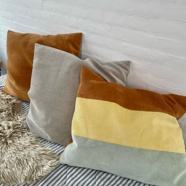 Pudebetræk i gul, cognac og beige fløjl.