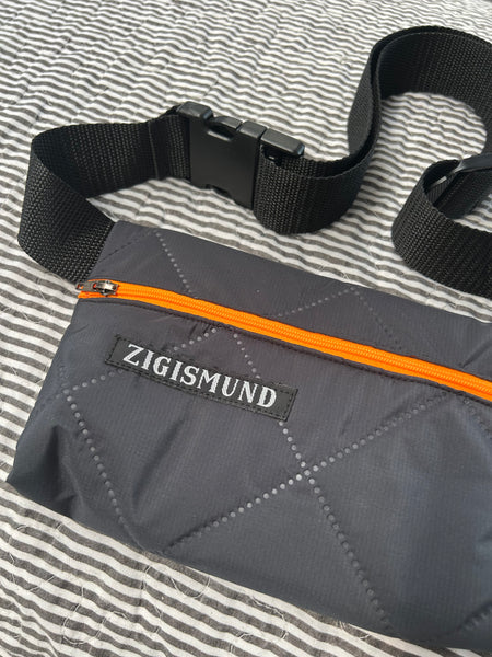 Bæltetaske i charcoal med orange lynlås.