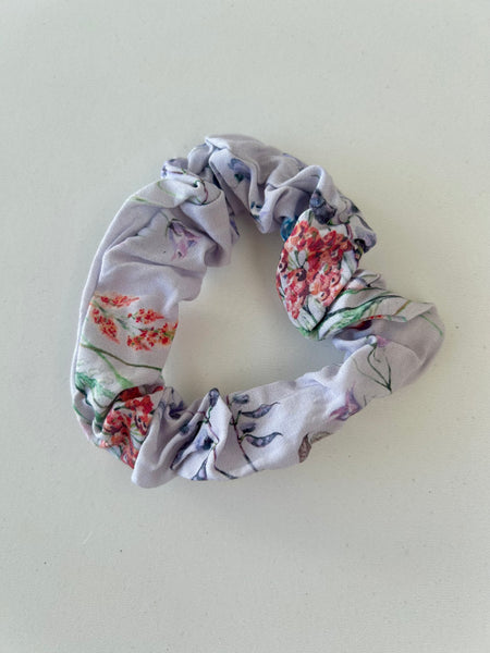 Smal scrunchie i lys lilla med blomster.
