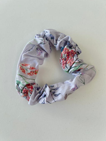 Smal scrunchie i lys lilla med blomster.