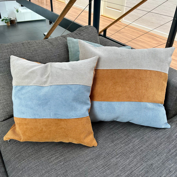 Pudebetræk i gyldenbrun, mørk kit og pastelblå, og med gyldenbrun bagside