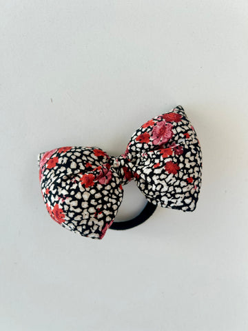 Fluffy sløjfe med blomster i rød, hvid og sort.