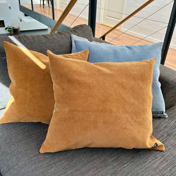 Pudebetræk i lys salvie, gylden brun og pastel blå. Bagsiden er gylden brun.